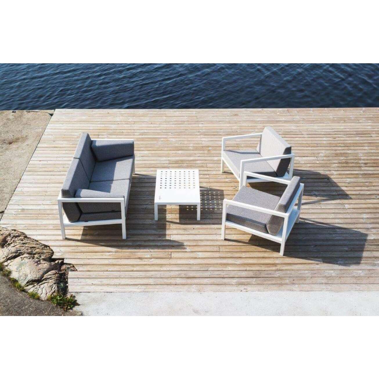 Sundays Design sofagruppe i hvit aluminium med lys grå puter på platting ved vann
