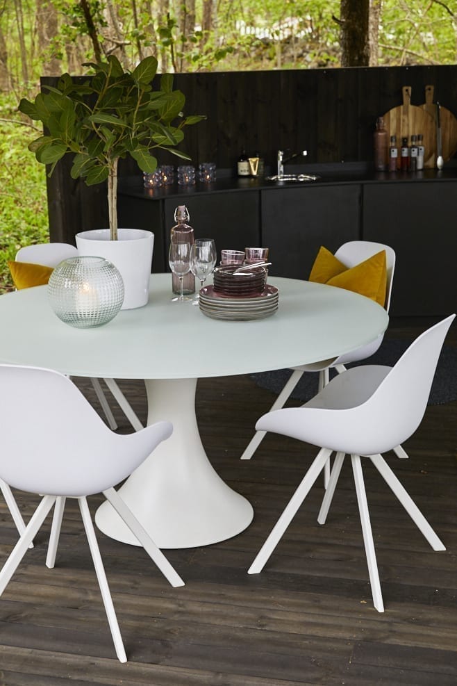 Rundt spisebord og spisestoler i hvit plast