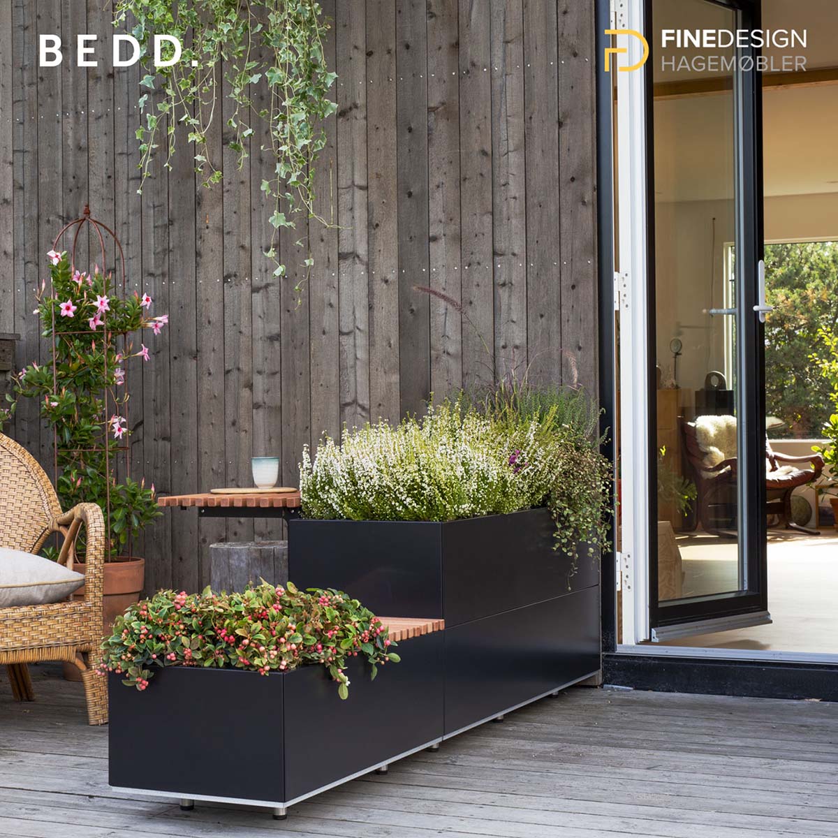 Sort BEDD plantekasse i to høyder med bord på veranda ved åpen dør